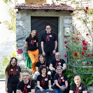 Gli abitanti del borgo storico Castè in posa con magliette coordinate dell'Associazione CastèVive! davanti alla struttura "Castè Style" near Cinque Terre, in Liguria (Italia).
